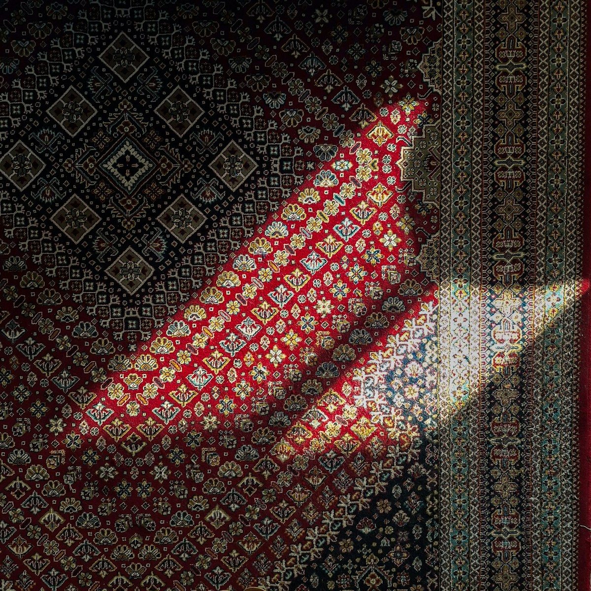 Intricate carpet with geometric patterns and sunlight