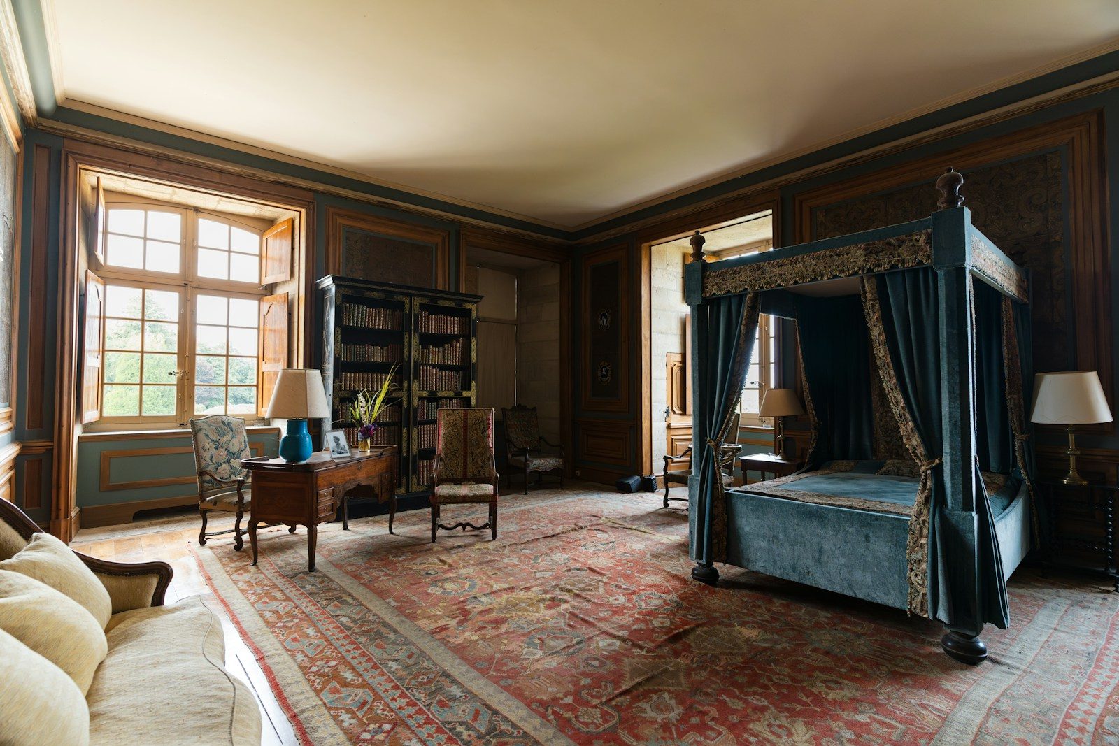 A bedroom with a canopy bed and a rug on the floor